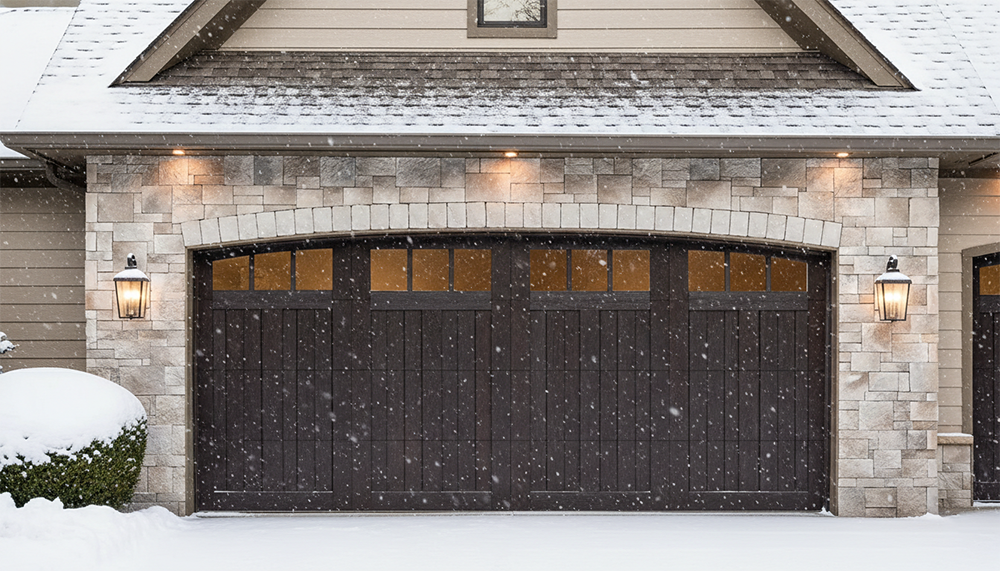 An Elegant Dark Wood-Tone Carriage House Garage Door With Arched Windows, Installed On A Stone Exterior Home During A Snowy Winter Day. This Durable Design Showcases The Premium Garage Door Options Available Through Lead Contractor Dmytro Shevchenko For Residents In North West Chicago.