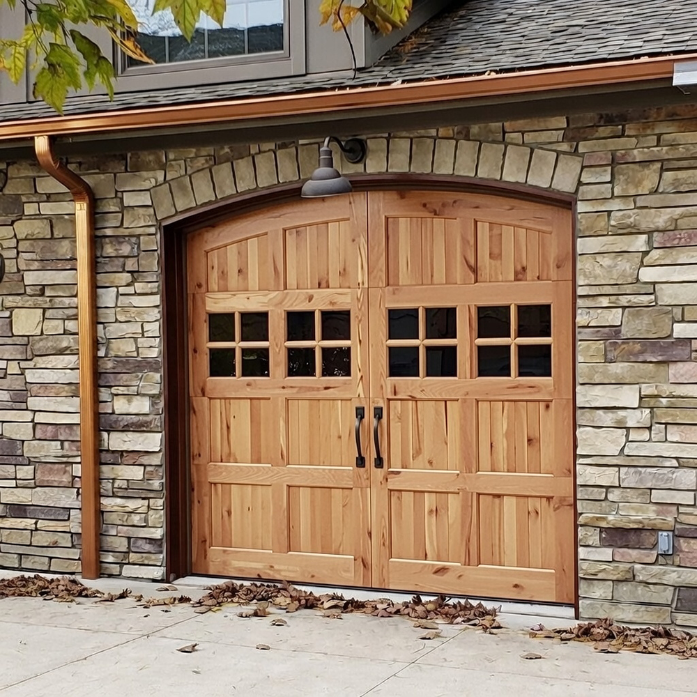 Light Wood Carriage-Style Design With An Arched Top Set In A Stone Facade, Showcasing Premium Garage Door Options Installed By Lead Contractor Dmytro Shevchenko In North West Chicago.