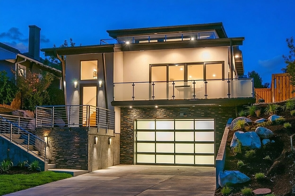 New Style Garage Doors: 2026 Trends &Amp; Modern Designs For Chicago Homes Modern Hillside Home At Dusk Featuring An Illuminated Frosted Glass Design As An Example Of Luxury Garage Door Options, Installed By Lead Contractor Dmytro Shevchenko In North West Chicago.