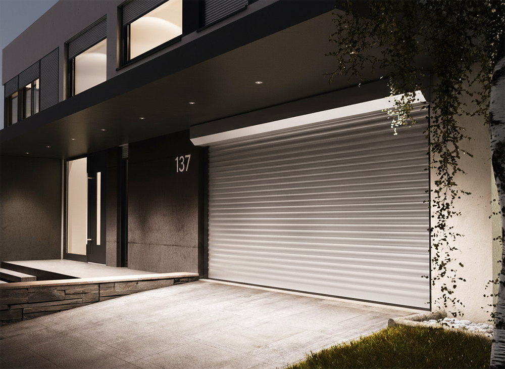 A Sleek, Modern White Horizontal Slat Roll-Up Garage Door Illuminated At Night On A Contemporary Dark-Toned Home, Showcasing The Premium Garage Door Options Available From Lead Contractor Dmytro Shevchenko In The North West Chicago Area.