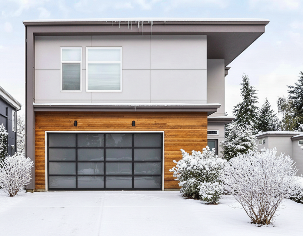 A Modern Home Featuring A Sleek Black-Framed Glass Garage Door Set Against Warm Wood Siding In A Snowy Landscape. This Contemporary Design Highlights The Stylish Garage Door Options Provided By Lead Contractor Dmytro Shevchenko For Residents In North West Chicago.
