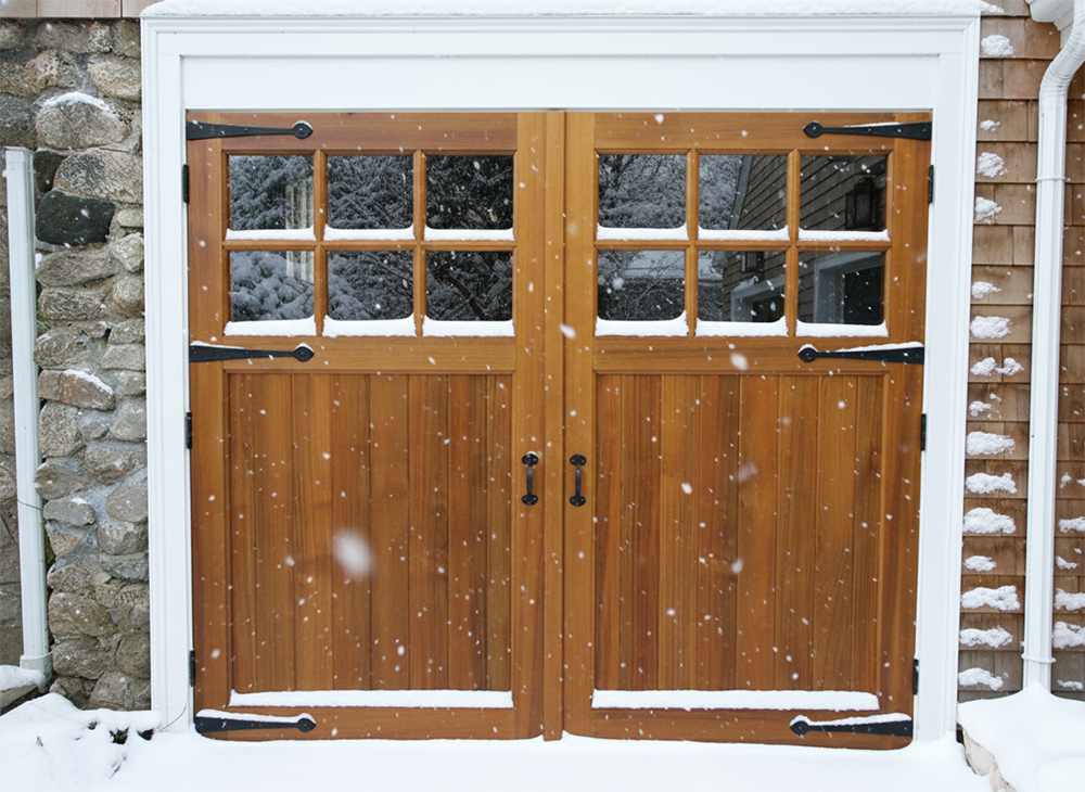 Close-Up Of Wooden Side-Hinged Garage Doors With Glass Panels And Decorative Black Hardware Amidst Falling Snow, Illustrating High-End Garage Door Options Available From Lead Contractor Dmytro Shevchenko For Homes In North West Chicago.
Title: