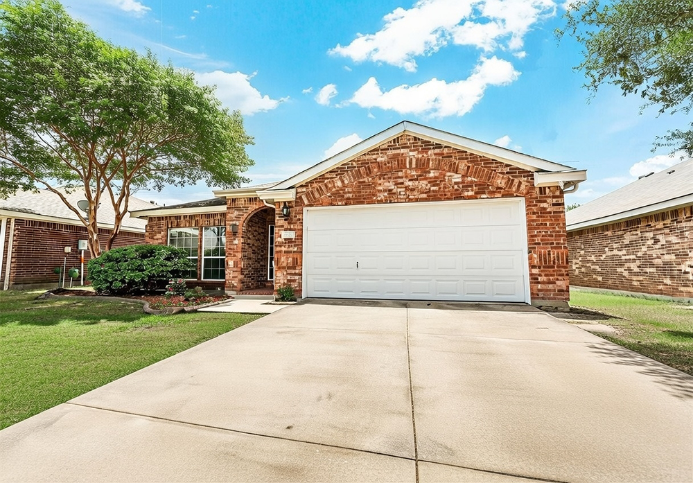 Traditional Garage Door Styles: The Timeless Choice For 2026 Traditional Garage Door Styles Featuring A Clean White Raised-Panel Sectional Overhead Garage Door With Classic Recessed Squares, White Trim Frame, Installed On A Warm Red Brick Ranch-Style Home With Arched Entryway, Gabled Roof, Mature Trees, Landscaped Yard And Wide Concrete Driveway Under Bright Blue Sky, North West Chicago. Lead Contractor Dmytro Shevchenko – Timeless Traditional Garage Door Styles.
