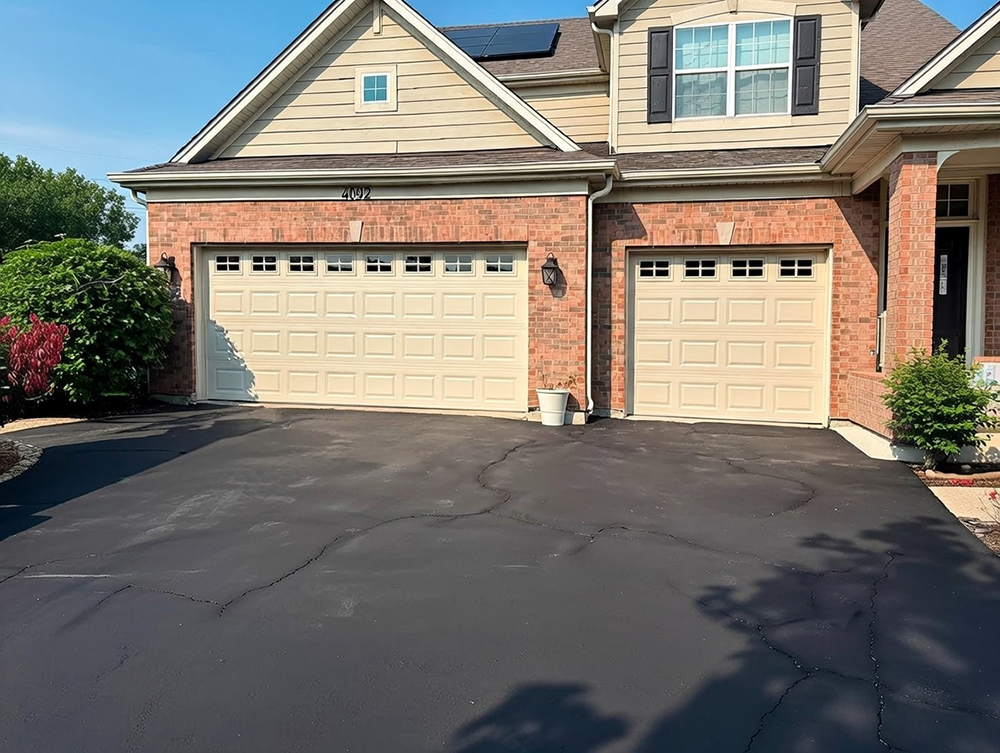 What Are The 5 Types Of Garage Doors? A 2026 Homeowner’s Guide Contemporary Two-Car Residential Home With Beige Raised-Panel Sectional Garage Doors Featuring Grid-Style Rectangular Windows, Installed On A Brick And Siding Facade With Gabled Roof, Solar Panels, Address 4092, Wide Asphalt Driveway, And Landscaped Front Yard Under Clear Blue Sky – Showcasing One Of What Are The 5 Types Of Garage Doors. Lead Contractor Dmytro Shevchenko, North West Chicago.